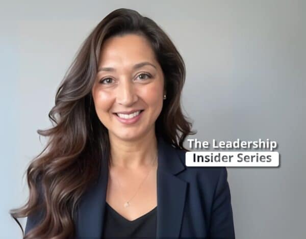 Woman with long brown hair wearing a navy blazer smiles at the camera; text on image reads "The Leadership Insider Series.