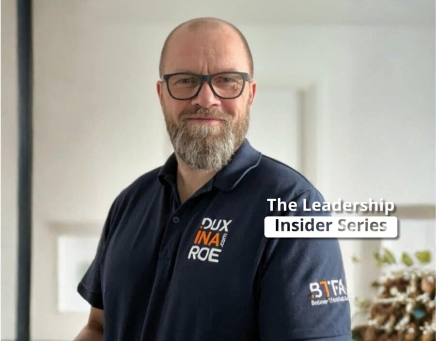 Man with glasses and a beard wearing a dark polo shirt with logos stands indoors; text overlay reads “The Leadership Insider Series,” exploring insights from neuroscience.