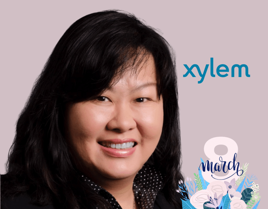 A woman smiling in front of a light background with the Xylem logo and "8 March" International Women’s Day graphic in the corner.